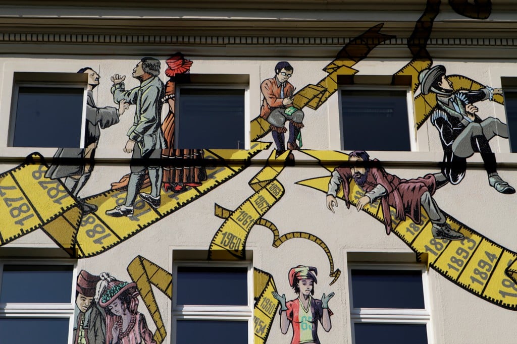 Wandbild zur Geschichte des Maßschneiderhandwerks – Detail Obergeschoss mit Maßband-Motiv